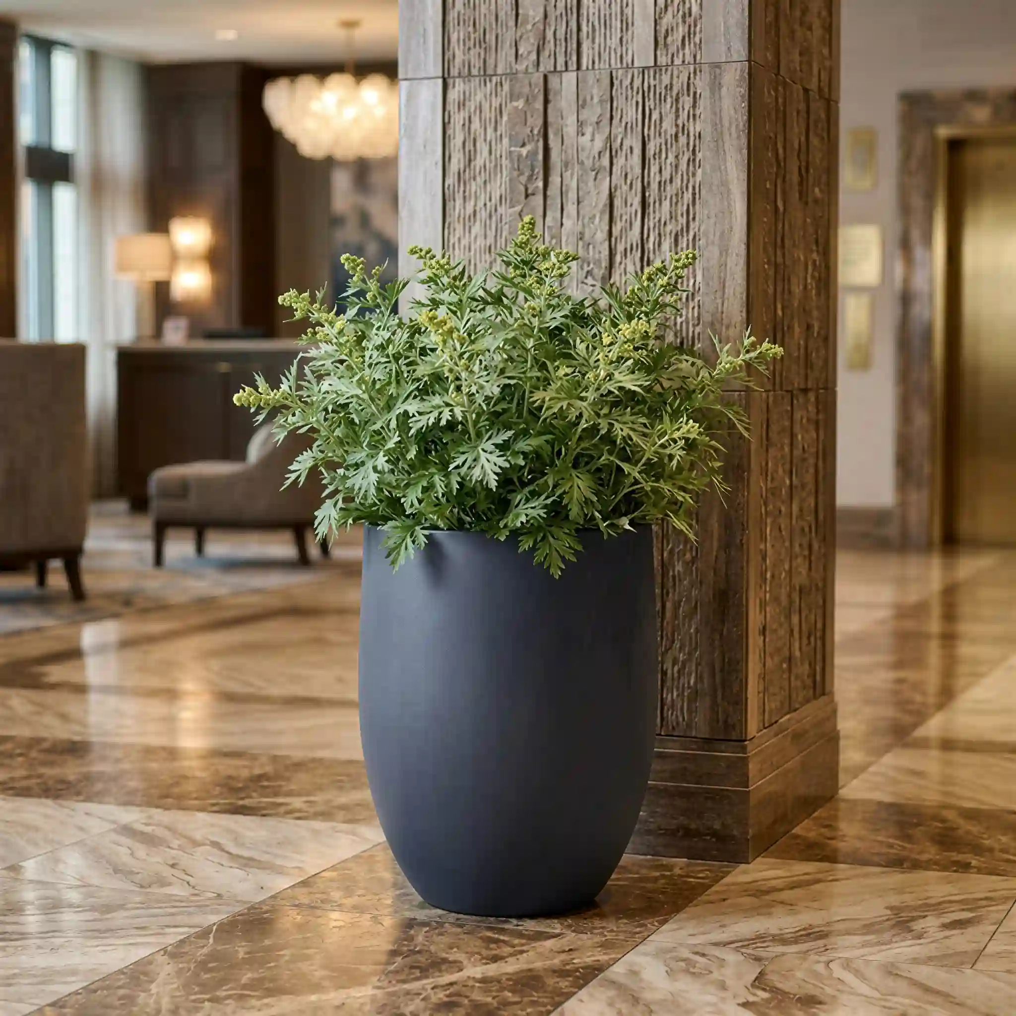 Large charcoal indoor concrete planter with vibrant greenery on a marble floor.
